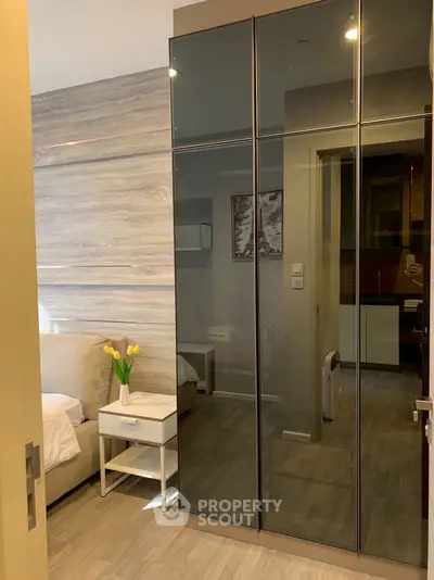 Modern bedroom with sleek mirrored wardrobe and cozy decor