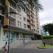 Modern apartment building exterior with lush greenery and palm trees