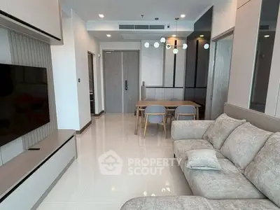 Modern living room with sleek furniture and elegant dining area in open layout apartment.