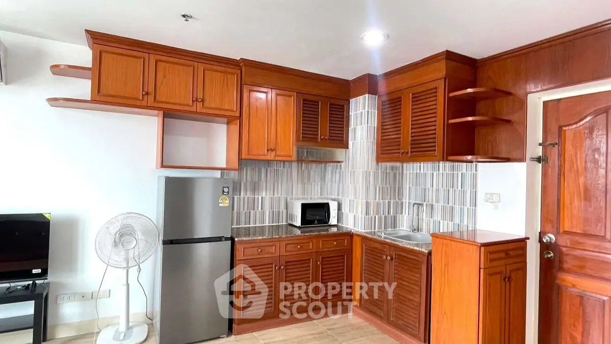 Charming kitchen with wooden cabinets and modern appliances in cozy apartment.