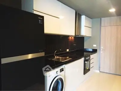 Modern kitchen with sleek black countertops and built-in appliances in a stylish apartment.