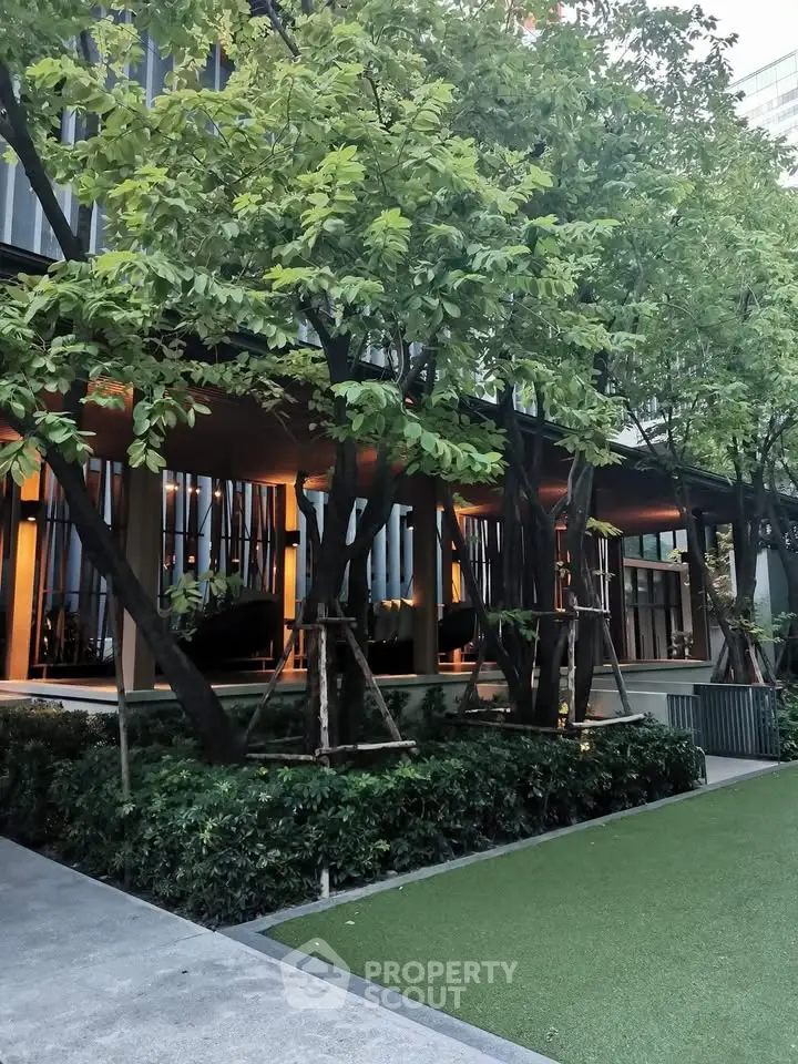 Modern building exterior with lush greenery and landscaped garden area.