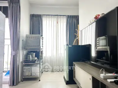 Modern living room with sleek TV setup and organized kitchen appliances