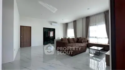 Spacious living room with modern brown sectional sofa and large windows