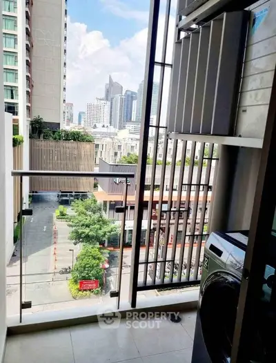 Modern balcony with city view and washing machine, perfect for urban living.