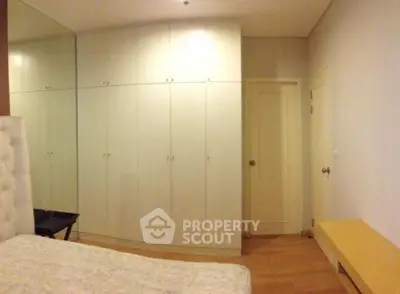 Spacious bedroom with built-in wardrobes and wooden flooring