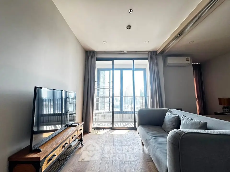 Spacious living room with modern decor and large windows offering city views.