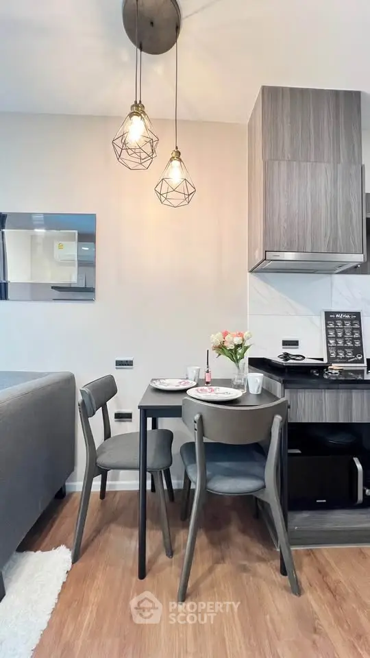 Modern dining area with stylish lighting and compact kitchen setup