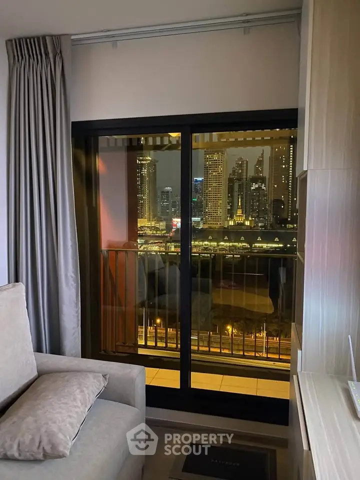 Modern living room with city view from balcony, featuring cozy seating and elegant curtains.