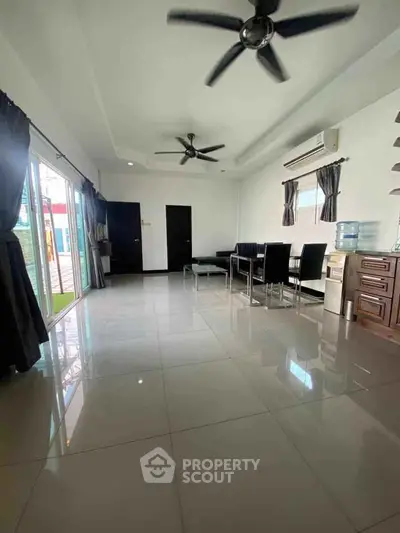 Spacious modern living room with dining area and large windows for natural light.