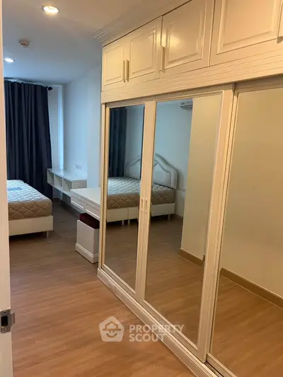 Spacious bedroom with mirrored wardrobe and cozy bed in modern apartment