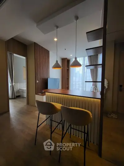 Modern open-plan living space with stylish lighting and wooden accents