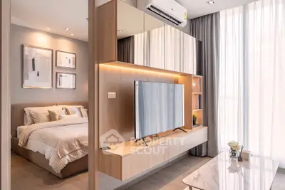 Modern bedroom with stylish decor and wall-mounted TV, featuring large windows and elegant furnishings.