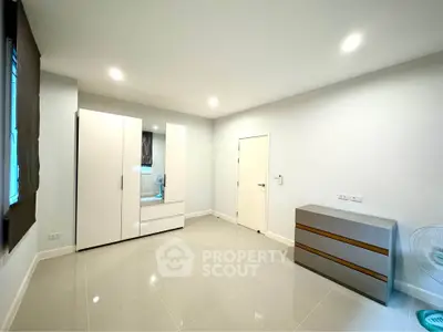Spacious unfurnished room with modern wardrobe and sleek tile flooring
