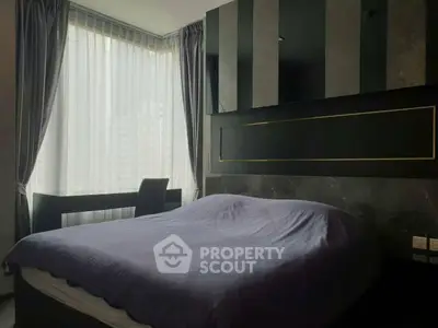 Luxurious bedroom with modern decor and large window offering city views.