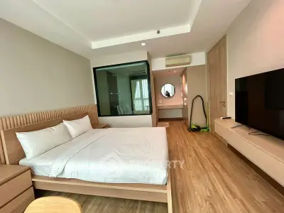 Modern bedroom with wooden flooring, large bed, and flat-screen TV in a stylish apartment.