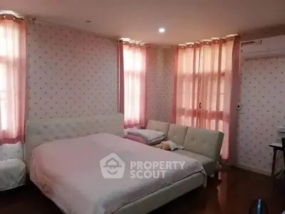 Cozy bedroom with soft pink curtains and elegant furnishings, perfect for relaxation and comfort.