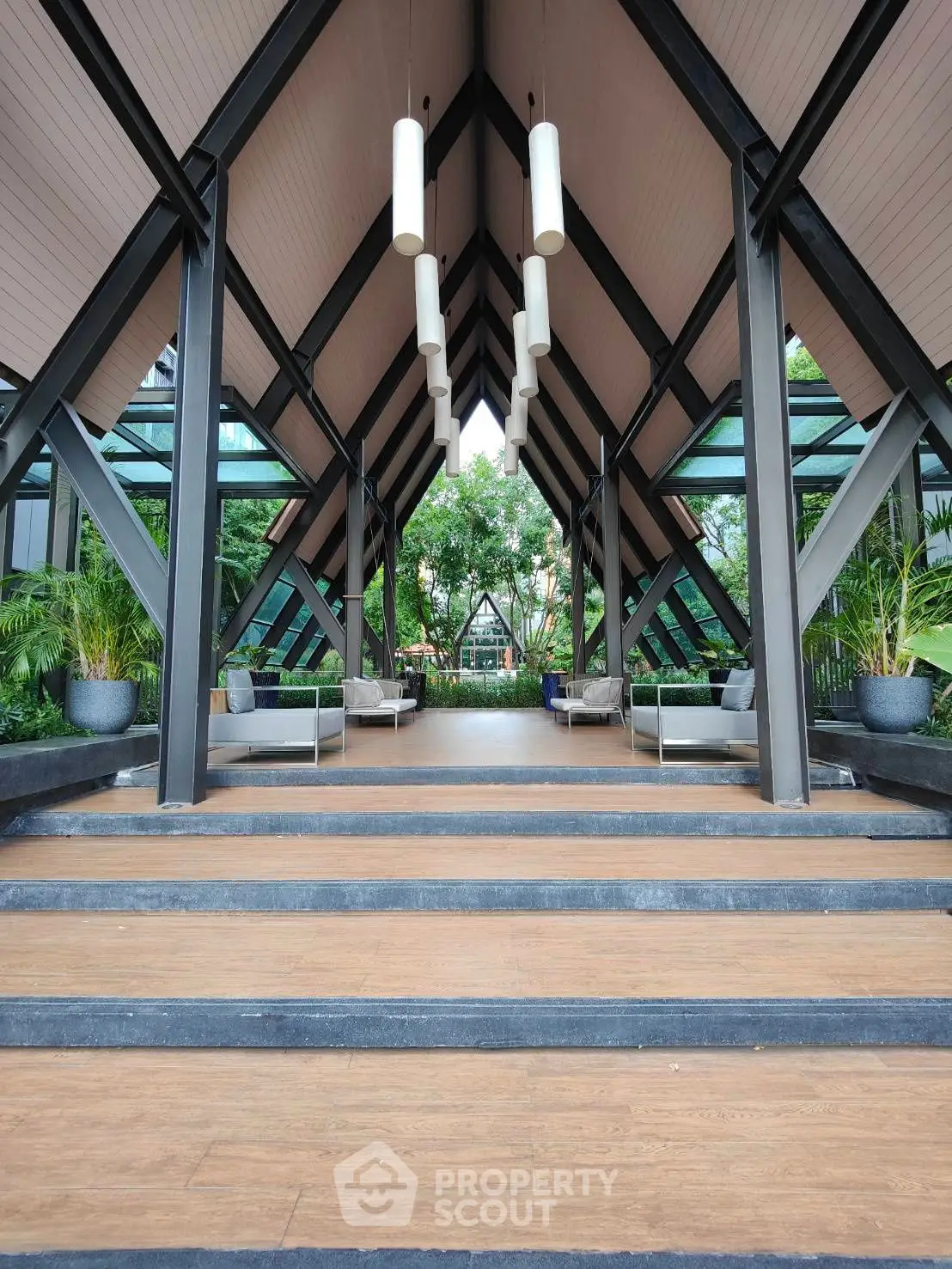 Stunning modern entrance with high ceilings and lush greenery