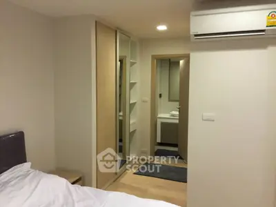 Modern bedroom with ensuite bathroom and mirrored wardrobe in stylish apartment.