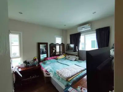 Cozy bedroom with natural light, featuring a double bed, air conditioning, and ample storage space.
