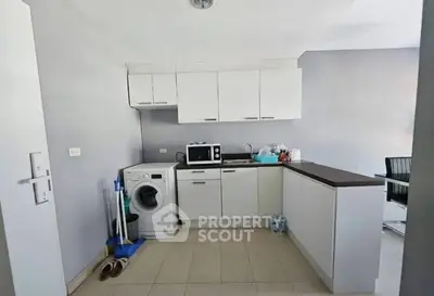 Modern kitchen with washing machine and microwave in a compact layout