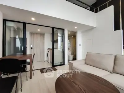 Modern living room with open layout and washing machine in stylish apartment.