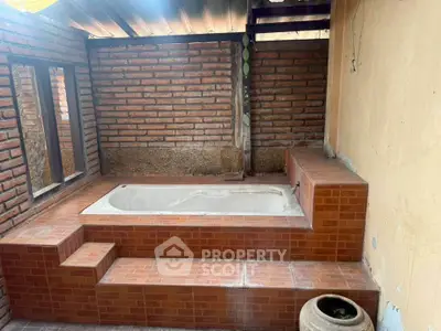 Unique rustic bathroom with brick walls and built-in bathtub