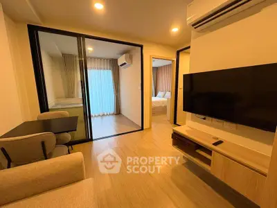 Modern apartment interior with open living room and bedroom, featuring sleek furniture and warm lighting.