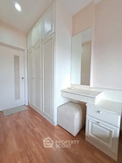 Elegant bedroom with built-in wardrobe and vanity in a cozy setting