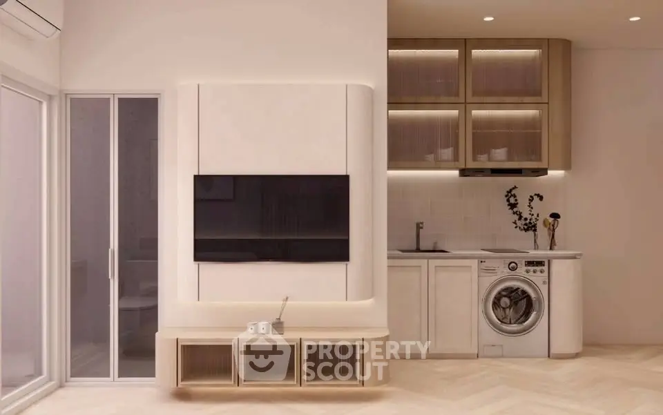 Modern living room with integrated kitchen and washing machine, featuring sleek cabinetry and minimalist design.