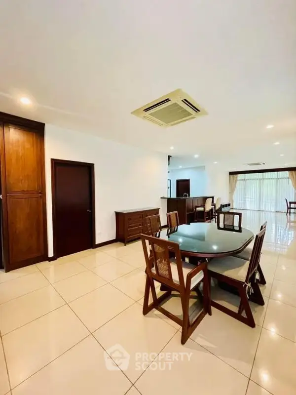 Spacious dining area with elegant wooden furniture and bright natural lighting.