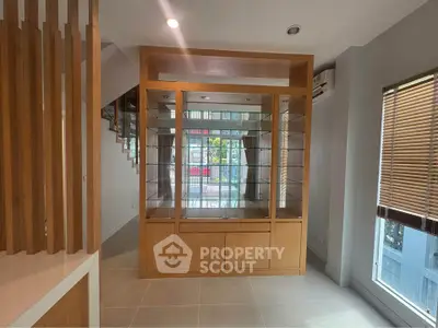 Spacious interior with wooden display cabinet and large windows for natural light.