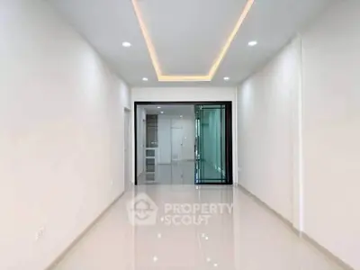 Spacious modern living room with sleek lighting and glossy floors, perfect for contemporary living.
