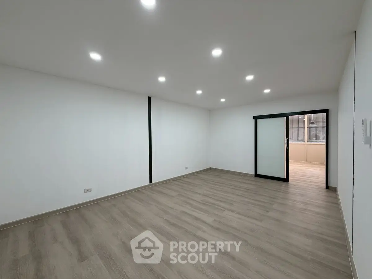 Spacious modern living room with sleek flooring and recessed lighting