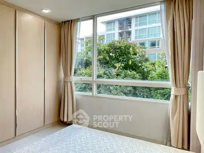 Bright bedroom with large window and garden view in modern apartment