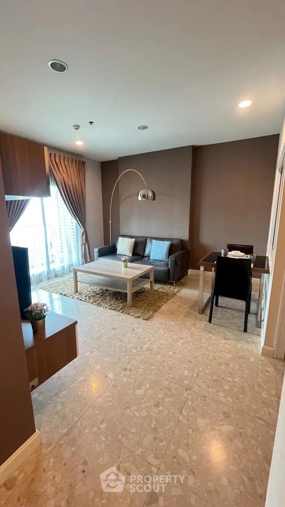 Spacious living room with modern decor and large windows in a stylish apartment.