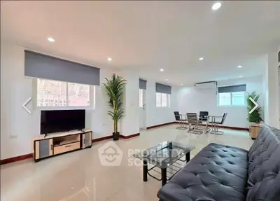 Spacious modern living room with sleek furniture and ample natural light, perfect for relaxation and entertainment.