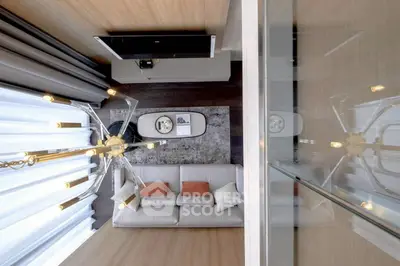 Modern living room with stylish chandelier and cozy sofa, featuring elegant decor and warm lighting.