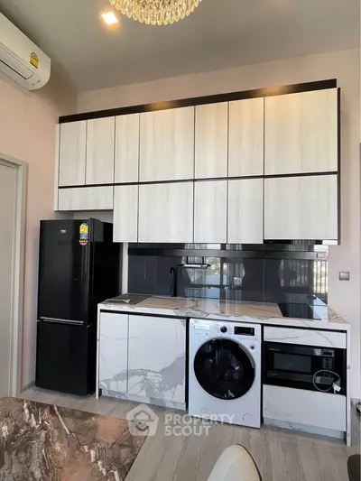 Modern kitchen with sleek cabinetry, integrated appliances, and marble countertops in a stylish apartment.