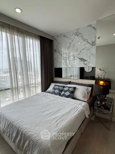 Modern bedroom with large windows and stylish decor in a high-rise apartment.