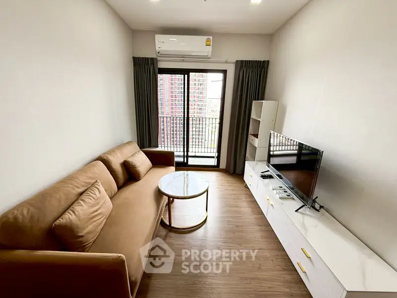 Modern living room with brown sofa, TV, and balcony view in a stylish apartment.