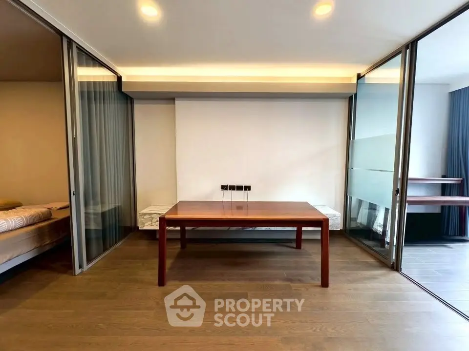 Modern interior with wooden flooring and sliding glass doors in a stylish apartment.