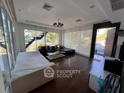 Spacious modern living room with large windows and elegant chandelier