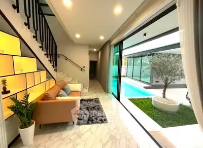 Luxurious modern living room with pool view and elegant staircase
