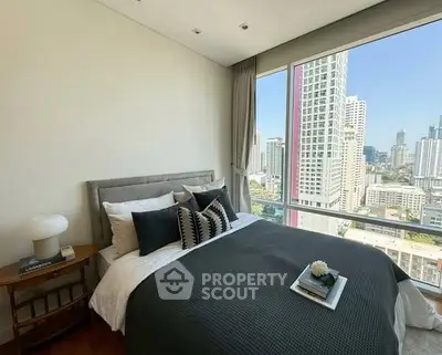 Luxurious bedroom with stunning city view and modern decor in high-rise apartment.