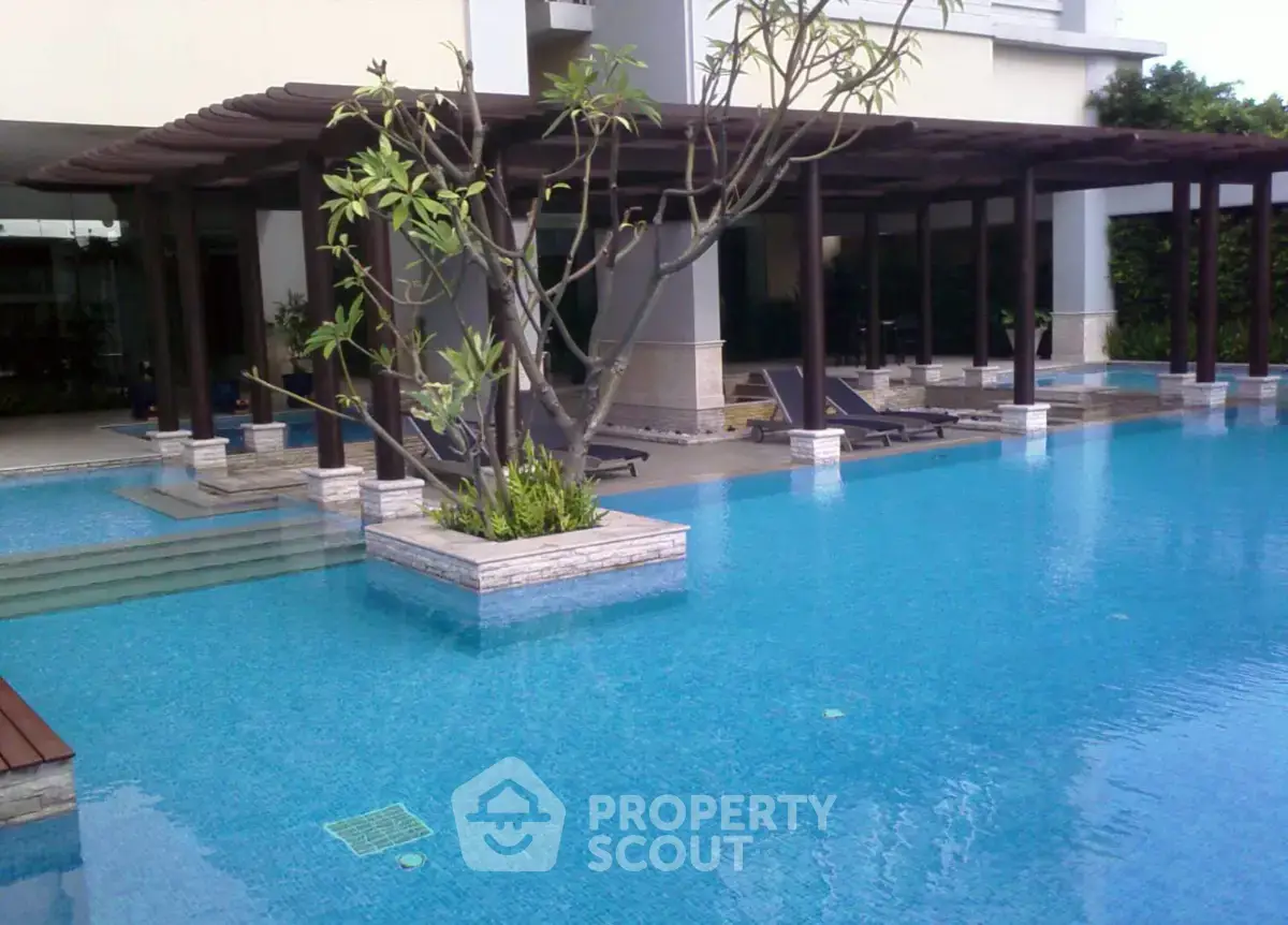 Luxurious poolside area with modern design and lush greenery, perfect for relaxation and leisure.