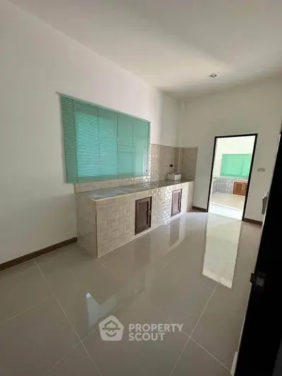 Spacious kitchen with tiled floor and modern cabinetry in a bright, airy home.