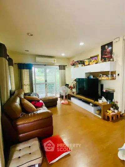 Spacious living room with modern decor and large TV, perfect for family gatherings.