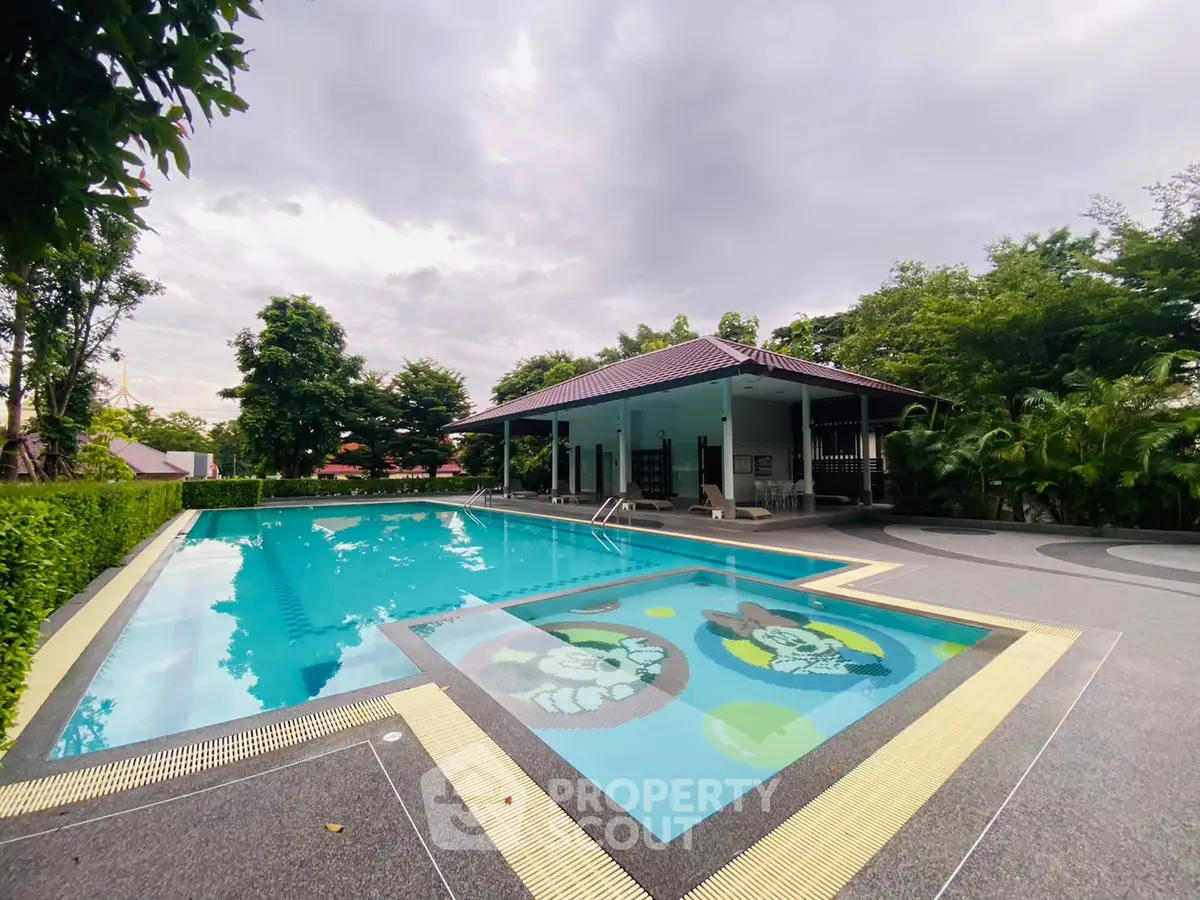 Luxurious outdoor swimming pool with lush greenery and modern amenities, perfect for relaxation and leisure.