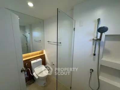 Modern bathroom with glass shower enclosure and sleek fixtures